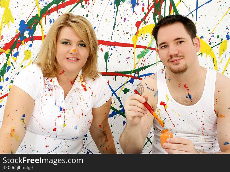 Young casual couple; splashed painted background. Young casual couple; splashed painted background