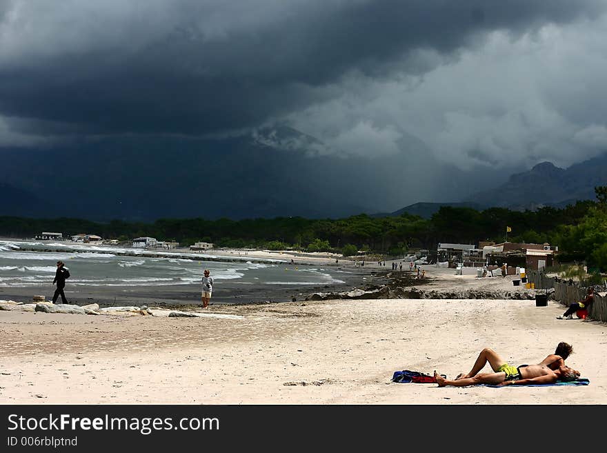 Corsica   Bay of Calvi, people on the beach before the storm,. Corsica   Bay of Calvi, people on the beach before the storm,