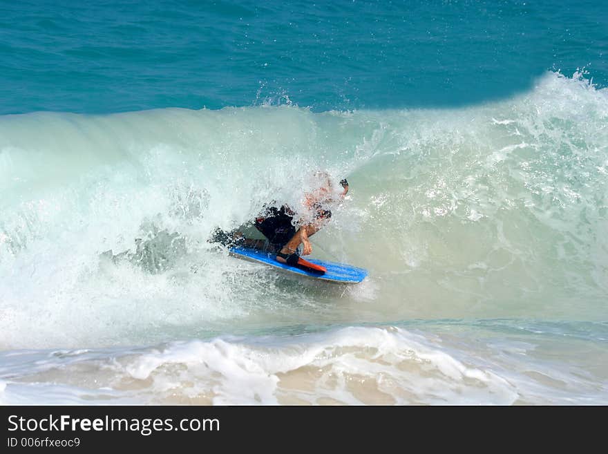 Bodyboarder rides a tube, dropknee style. Bodyboarder rides a tube, dropknee style.