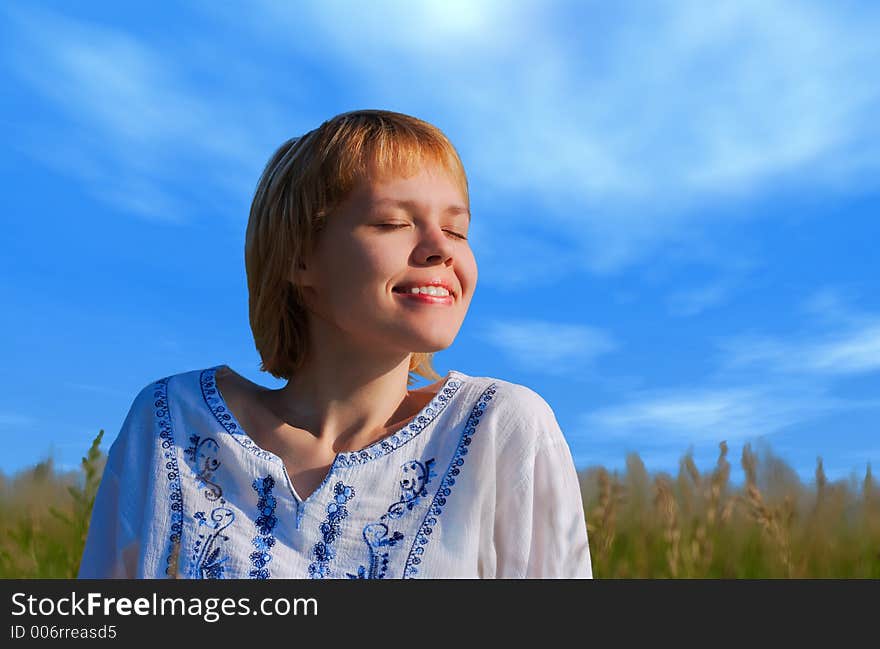 Beauty girl in field under clouds