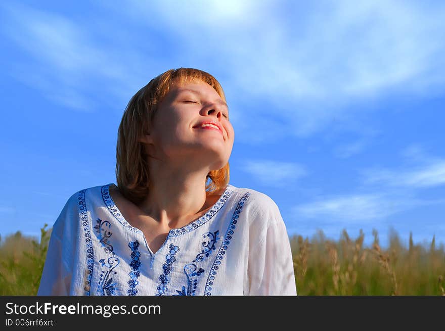 Beauty girl in field under clouds