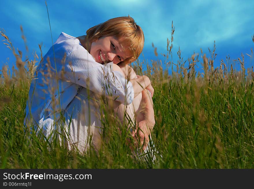 Beauty girl in field under clouds