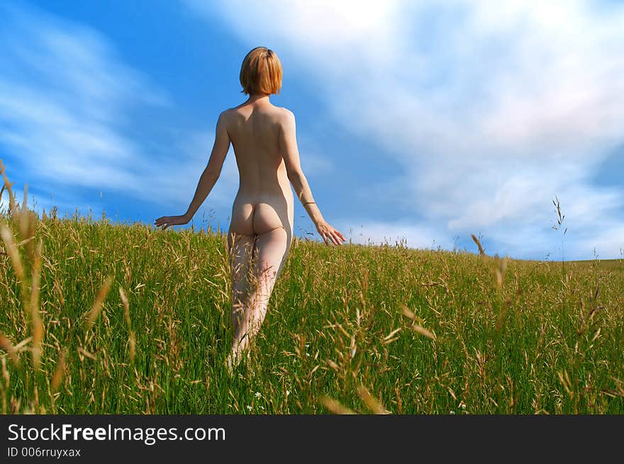 Beauty girl in field under clouds