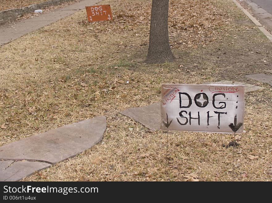 Handmade signs pointing to dog excrement. Handmade signs pointing to dog excrement