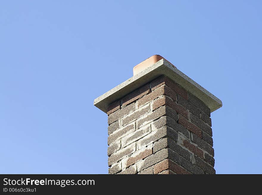 Multi Brown Brick Chimney Against a Blue Sky Background