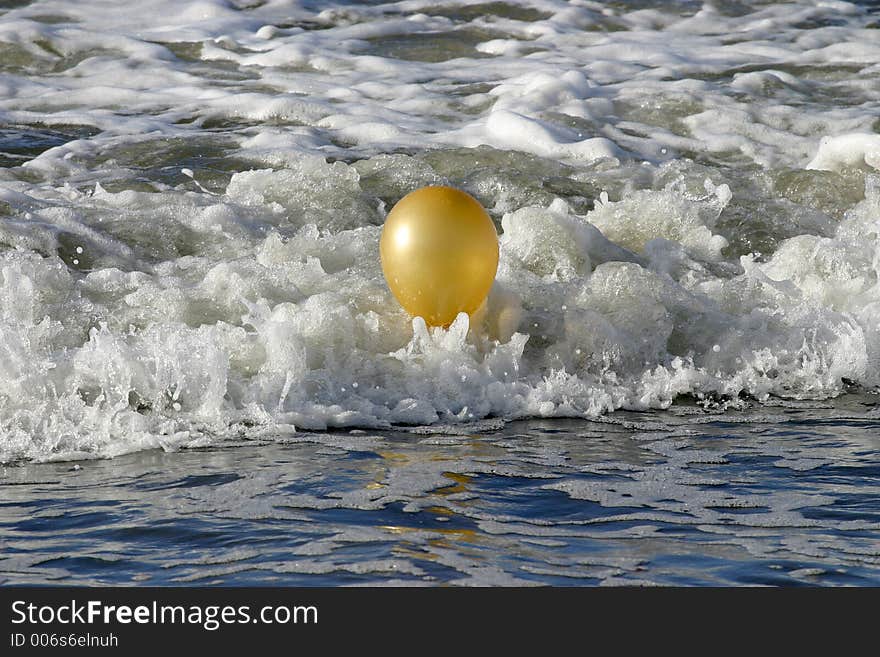 Golden Baloon bouncing in the waves could indicate success or trapped by success. Golden Baloon bouncing in the waves could indicate success or trapped by success