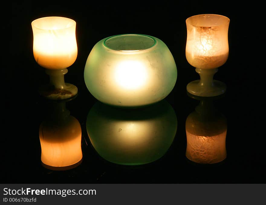 Cups and candles, black background. Cups and candles, black background