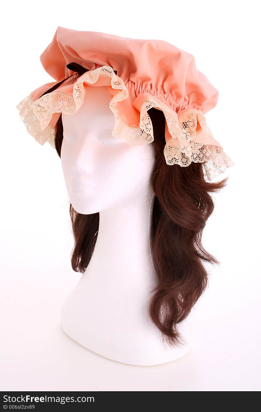 A ladies apricot bonnet with lace trim taken on a white mannequin head