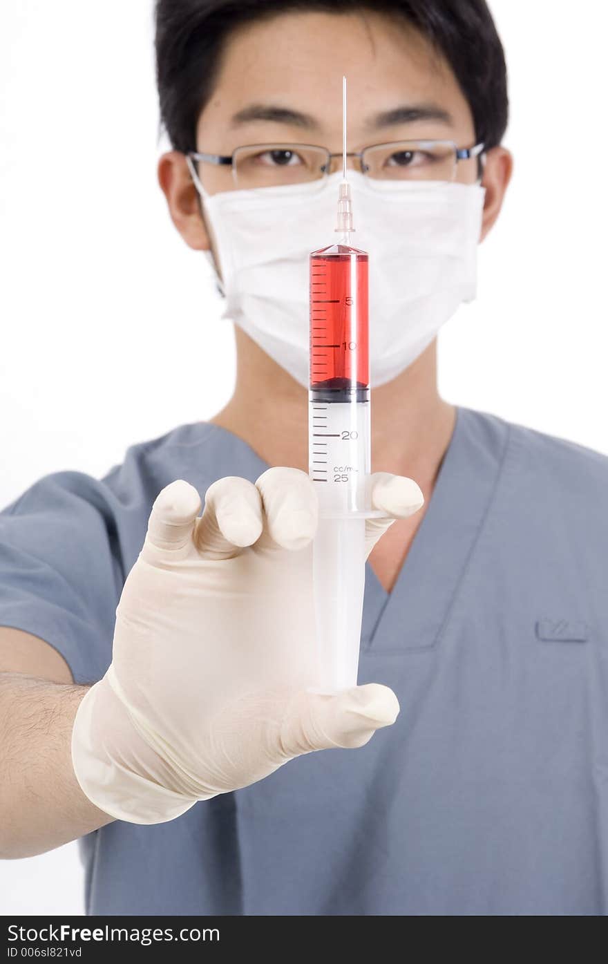 A young doctor holds a syringe of red liquid. A young doctor holds a syringe of red liquid