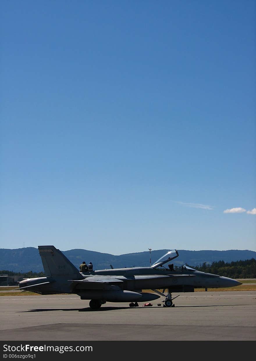 Two people sitting on top of old fighter jet. Two people sitting on top of old fighter jet.