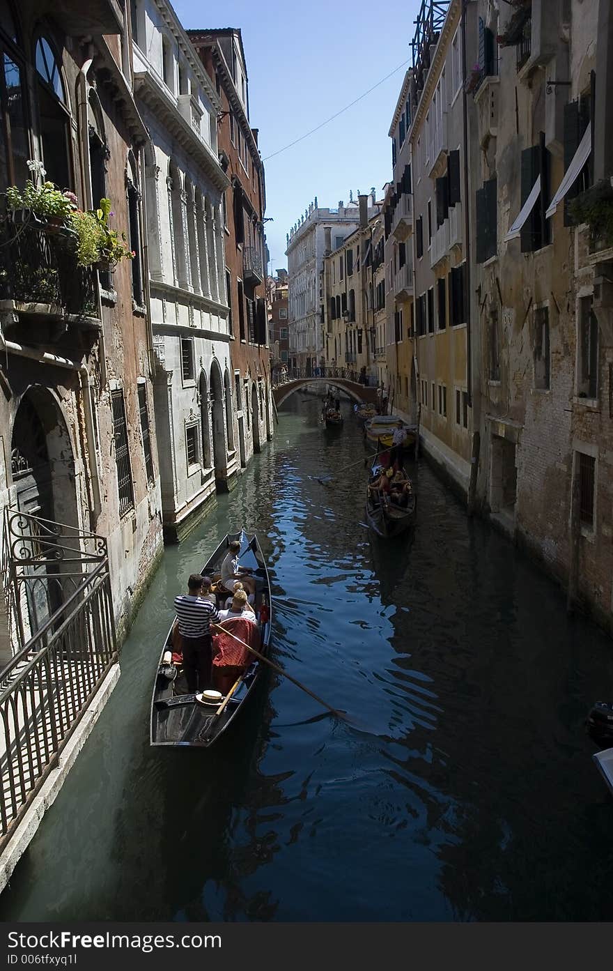 A canal in venice with gondolas and tourists. A canal in venice with gondolas and tourists