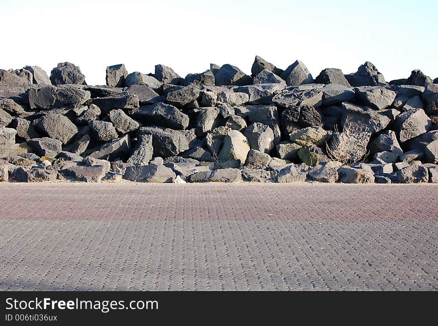 Dark stone dam over a parking