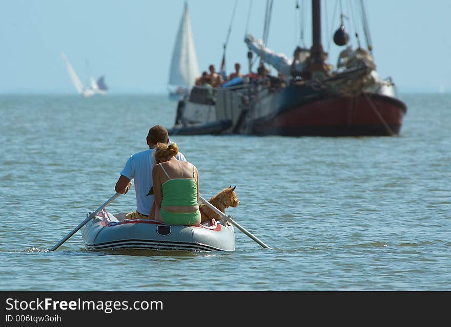 Couple with dog rowing towards the shore