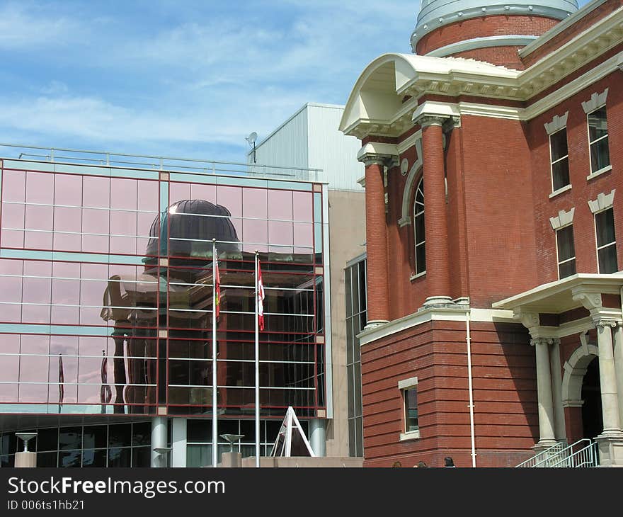 Old historic building reflected in new modern glass building. Old historic building reflected in new modern glass building