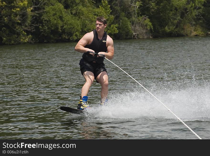 Man riding wakeboard at side of boat. Man riding wakeboard at side of boat