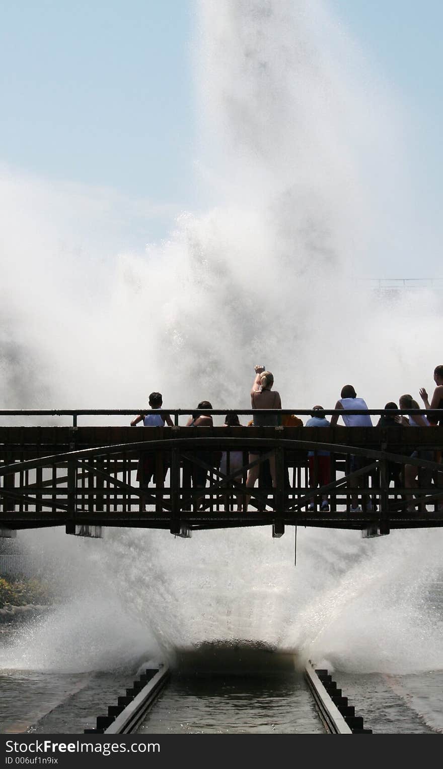 water ride splashing the people standing on the bridge.