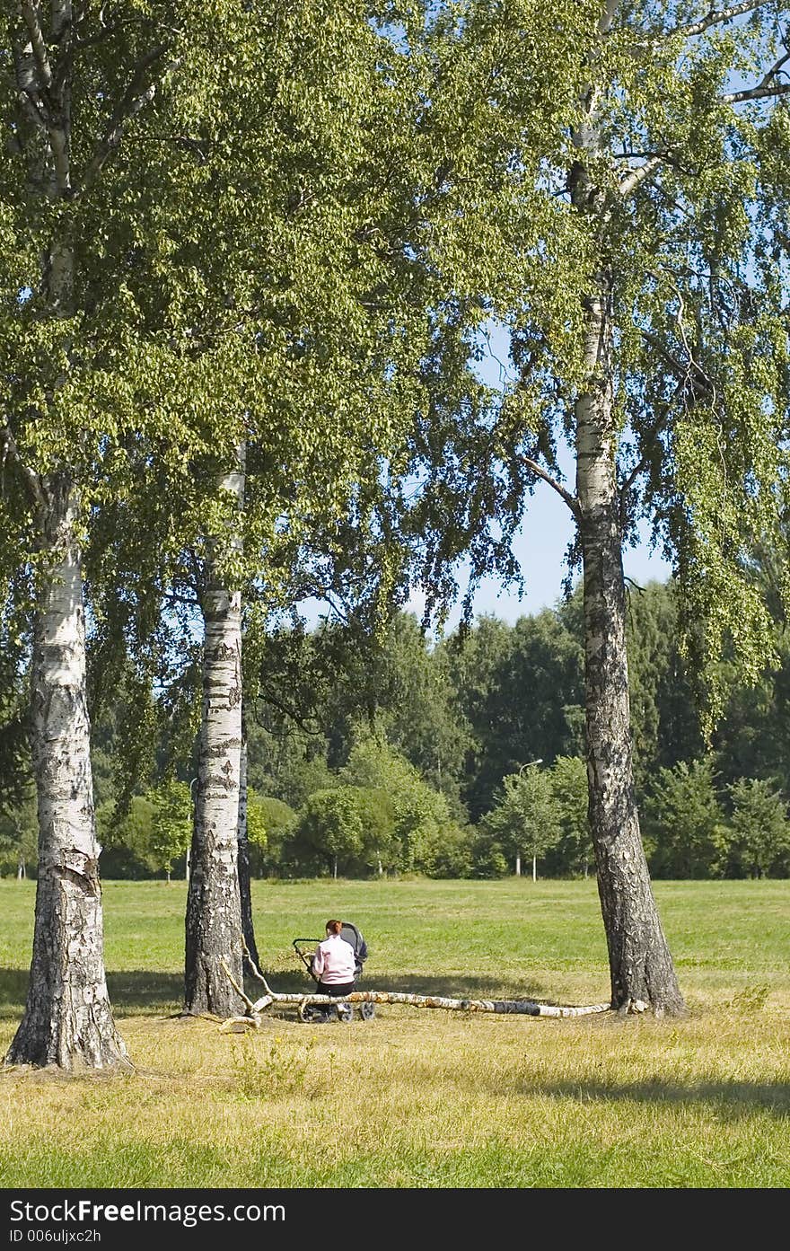 Mum has a rest with the child, near birches. Mum has a rest with the child, near birches