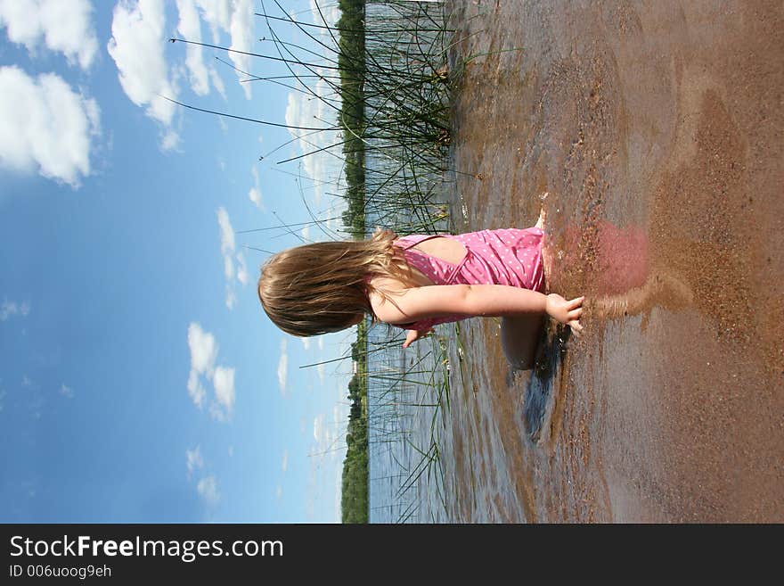 A little girl plays in the lake. A little girl plays in the lake