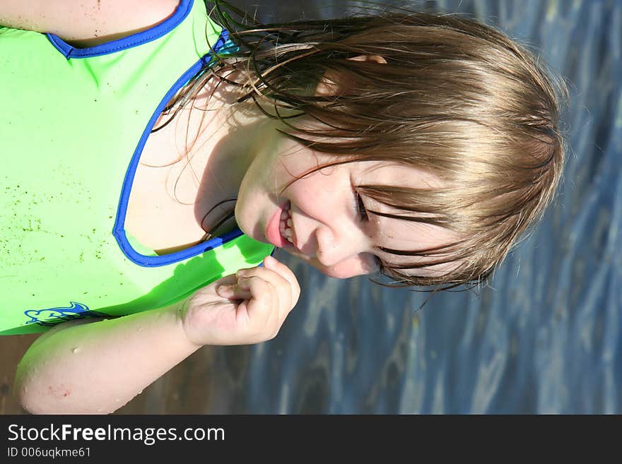 A toddler enjoys swimming with her life vest. A toddler enjoys swimming with her life vest.