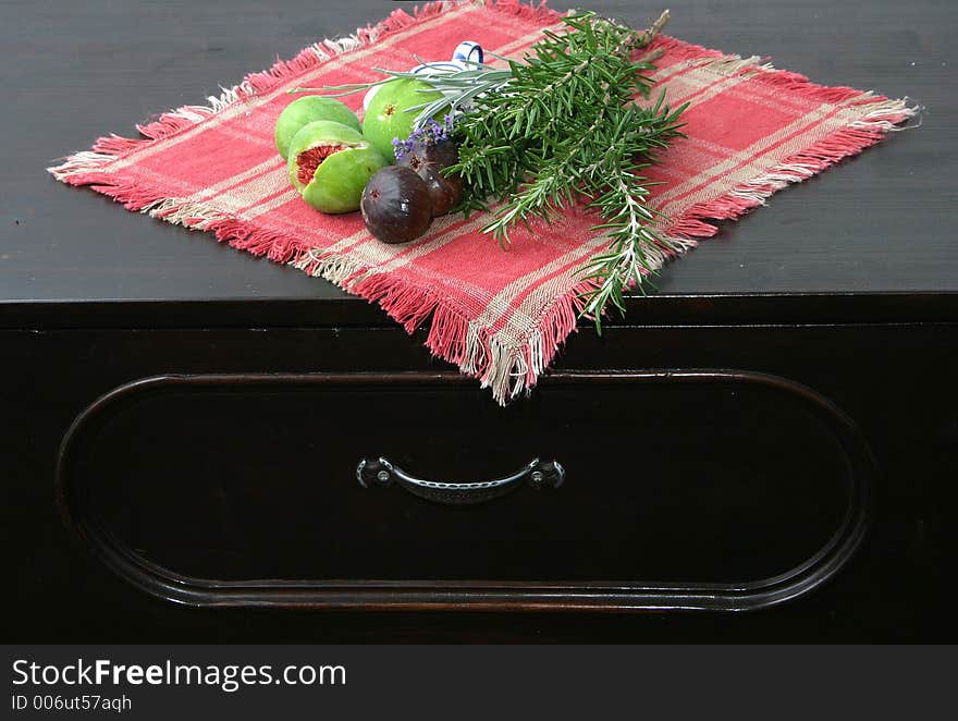 Setting with figs, rosemary and lavender on old chest of drawers. Setting with figs, rosemary and lavender on old chest of drawers