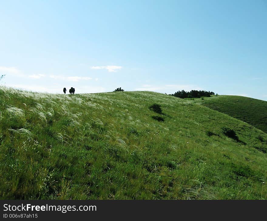 People are going along hill. People are going along hill