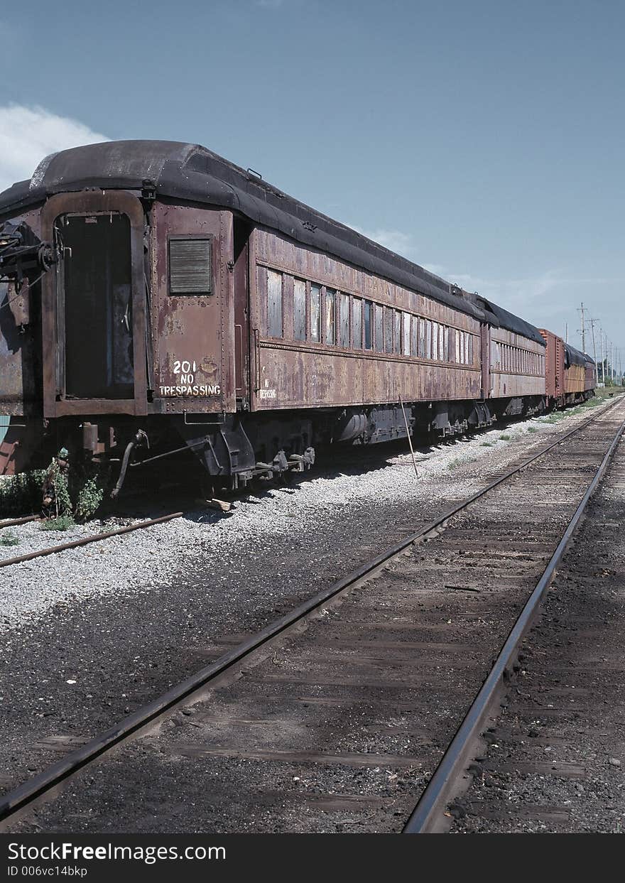 An old passenger train rotting away in a rail yard. An old passenger train rotting away in a rail yard.