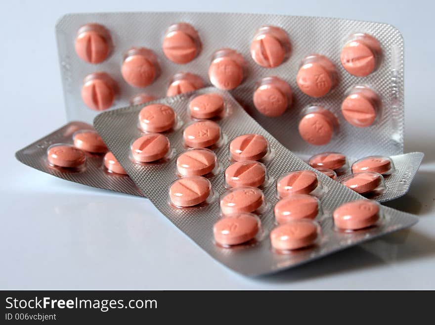 Pink pills isolated over white