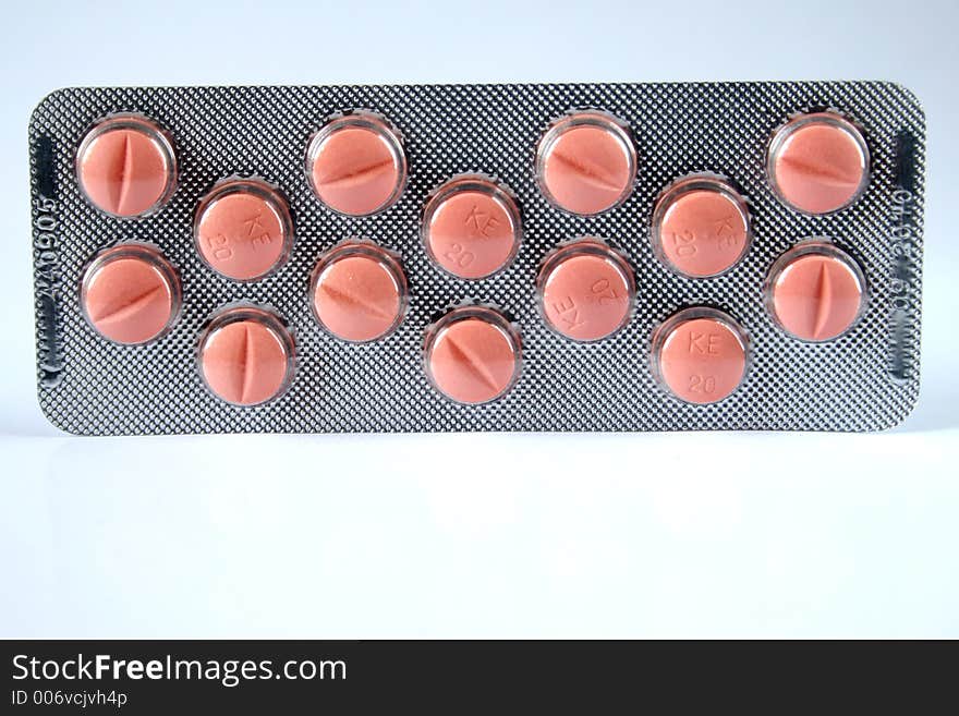 Pink pills isolated over white