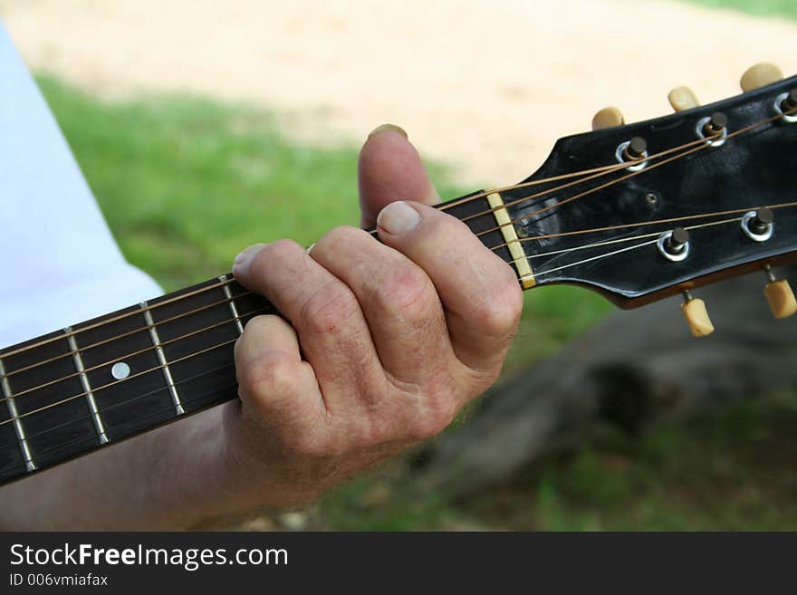 Aged hand playing guitar