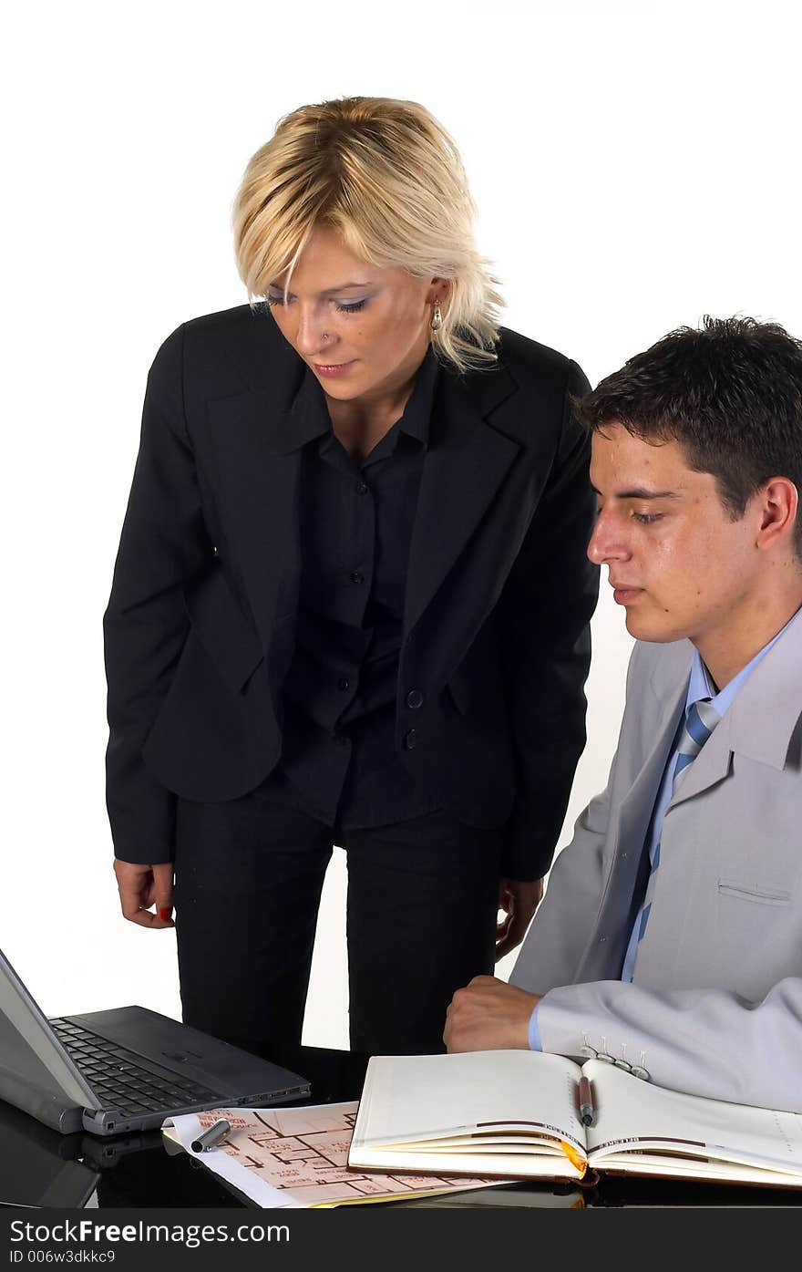 Businessman working at his desk and talking to a secretary. Businessman working at his desk and talking to a secretary