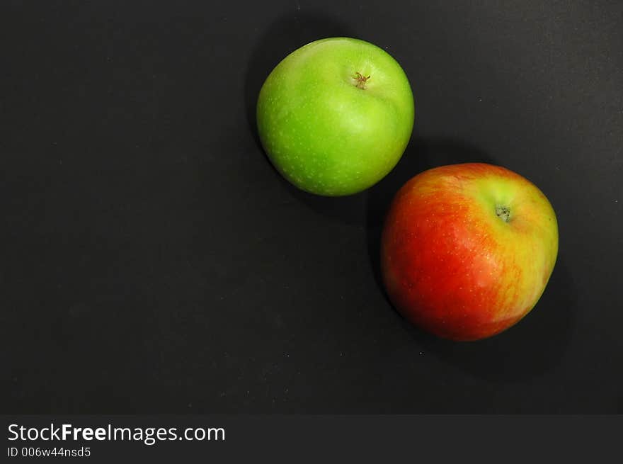 Green and red apple on black background with spotlight. Green and red apple on black background with spotlight