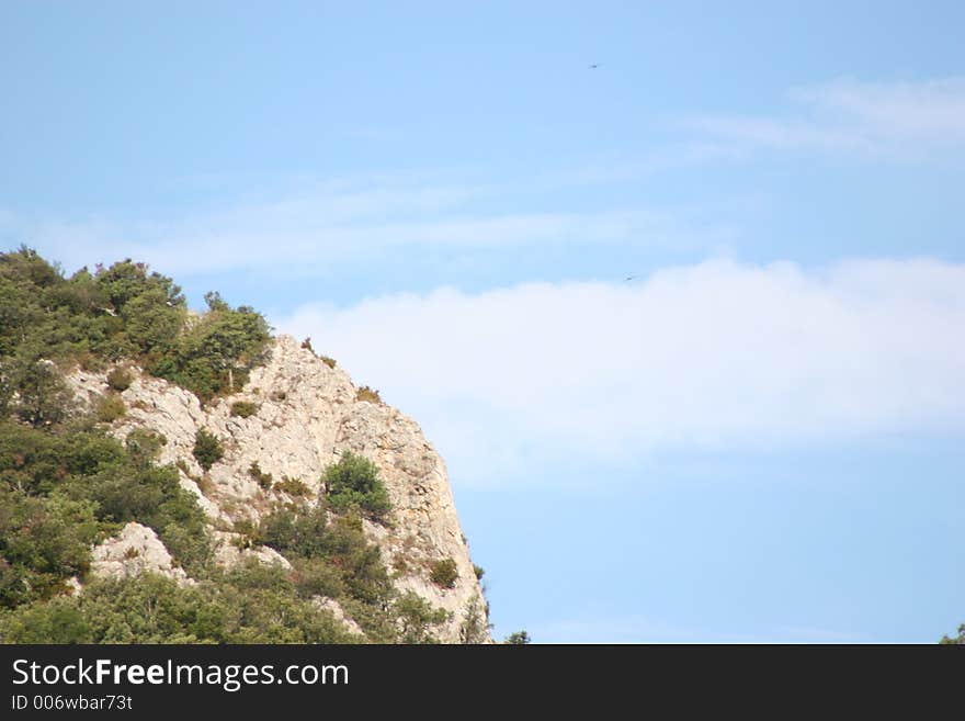 Cliff with tree and a wonderful cloudy sky