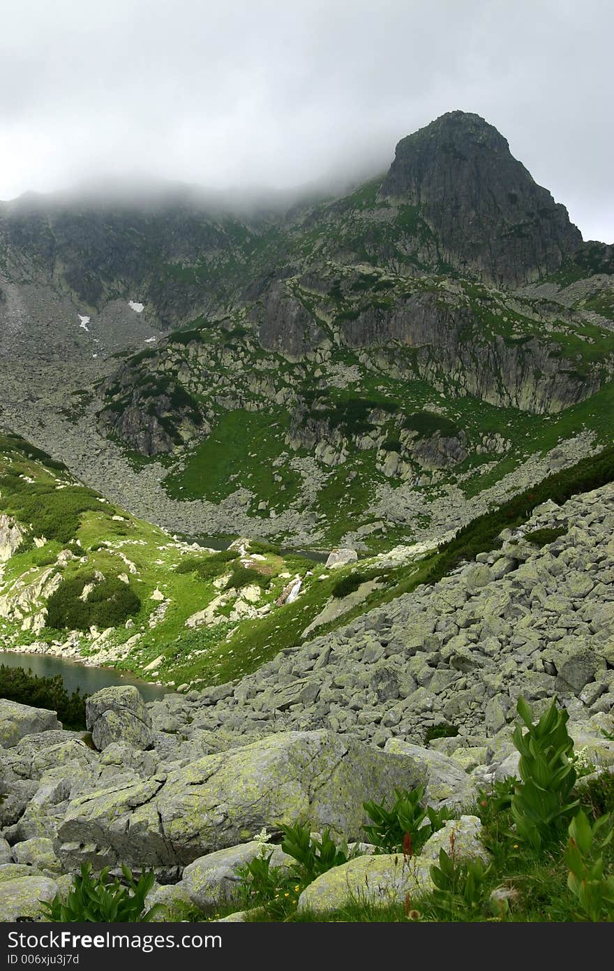 Judele Peak with small waterfall at the base in Retezat Mountains - Romania. Judele Peak with small waterfall at the base in Retezat Mountains - Romania