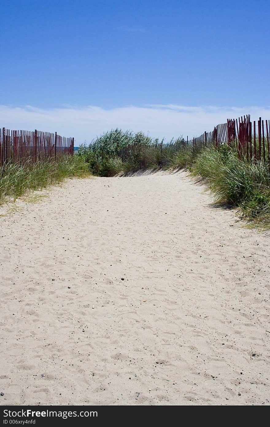 The wide sandy path beckons beachgoers to the ocean shore just past the horizon. The wide sandy path beckons beachgoers to the ocean shore just past the horizon.