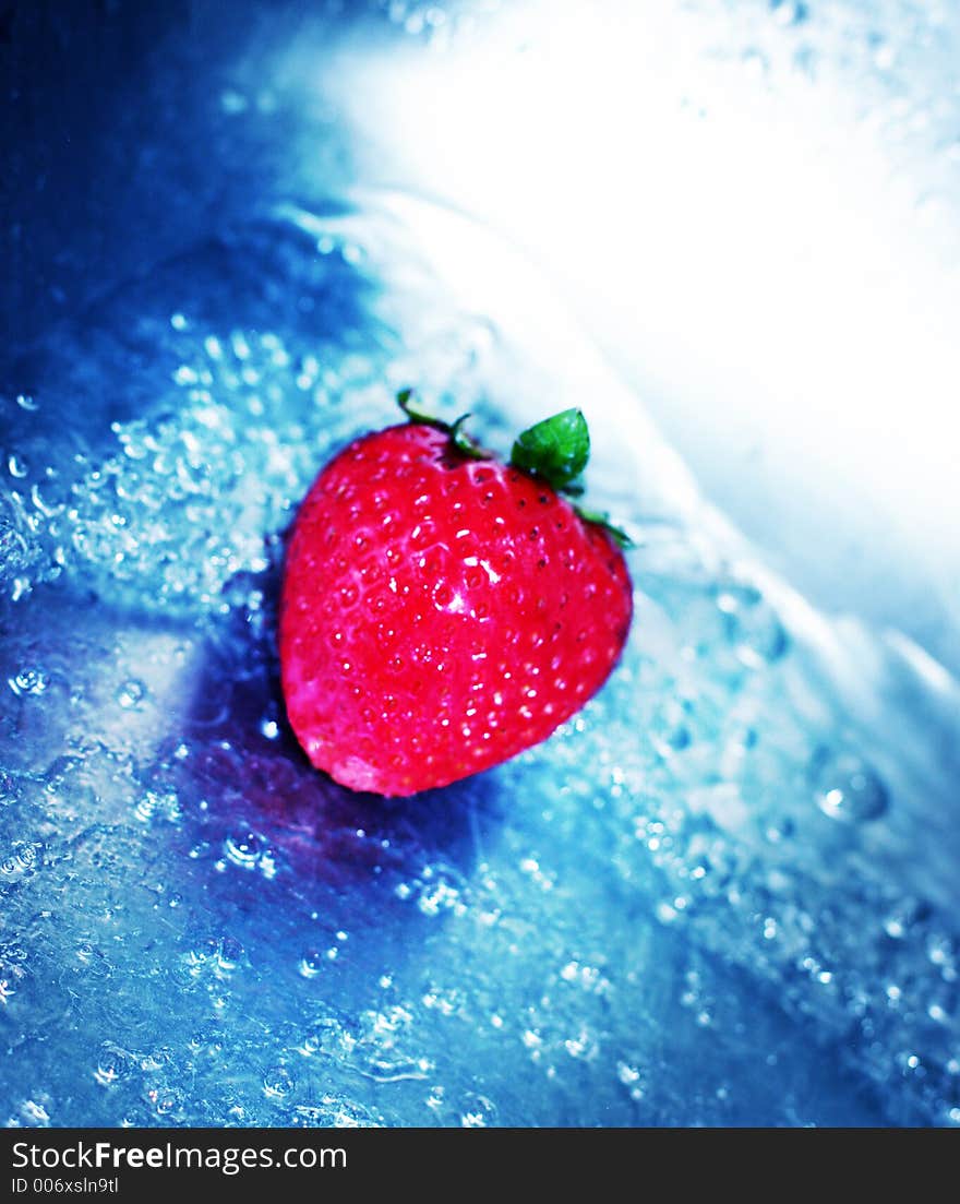 Rushing, blue water with fresh, red strawberry. Rushing, blue water with fresh, red strawberry