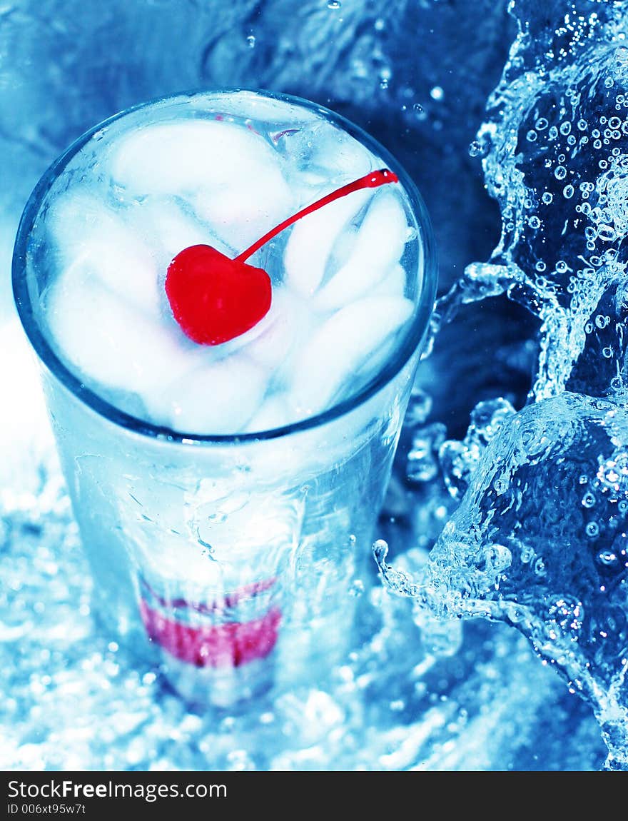 Red cherry in refreshing glass of water, next to tidal wave of water. Red cherry in refreshing glass of water, next to tidal wave of water