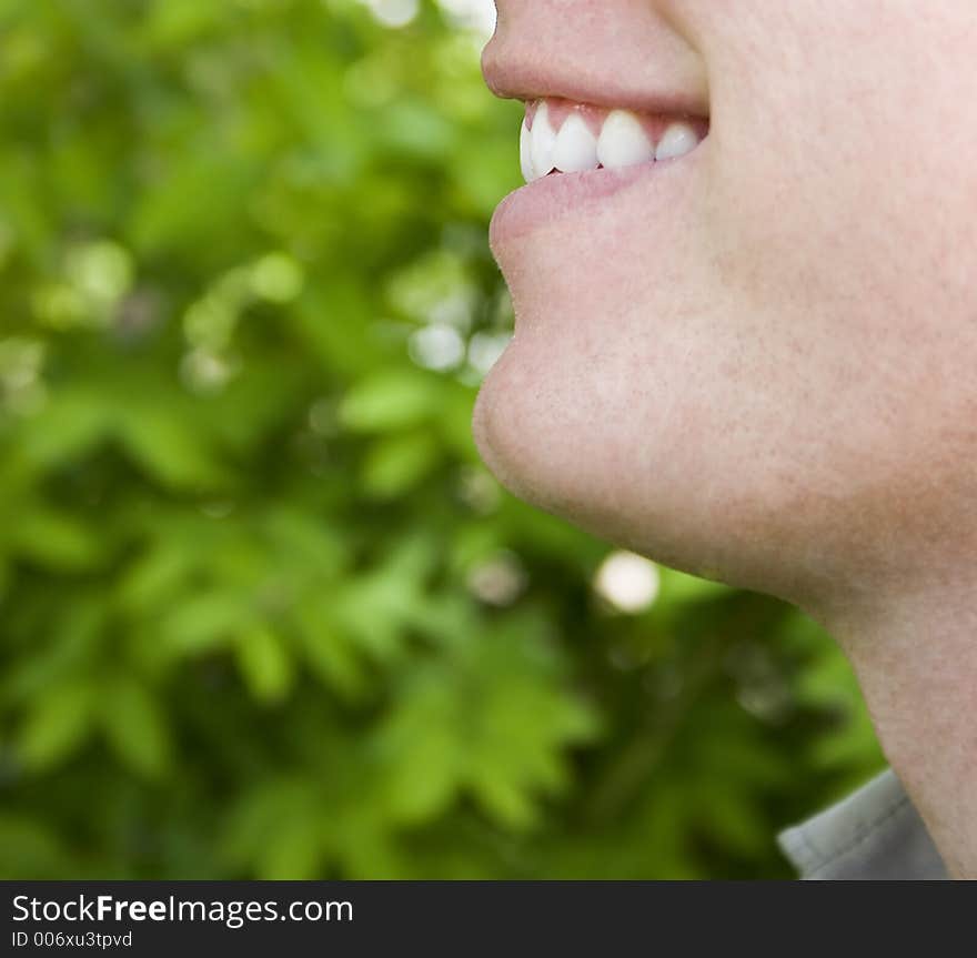 Man is smiling in front of green leaves. Man is smiling in front of green leaves