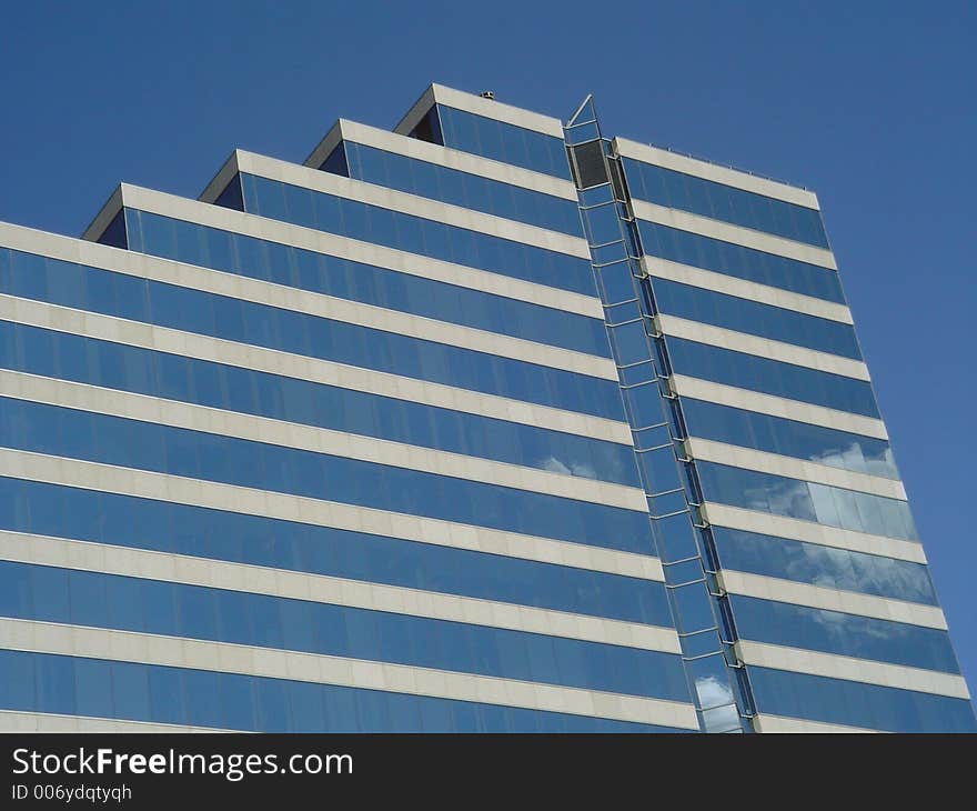 Corporative building with glass facade reflecting the sky. Good for bussiness image, as well as neutral background. Corporative building with glass facade reflecting the sky. Good for bussiness image, as well as neutral background.