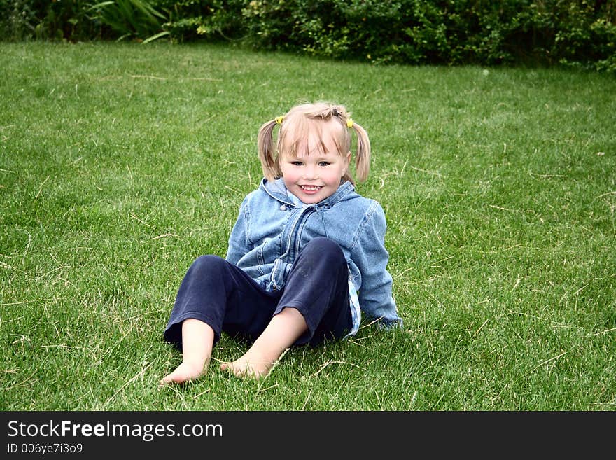 A girl sitting on the grass. A girl sitting on the grass