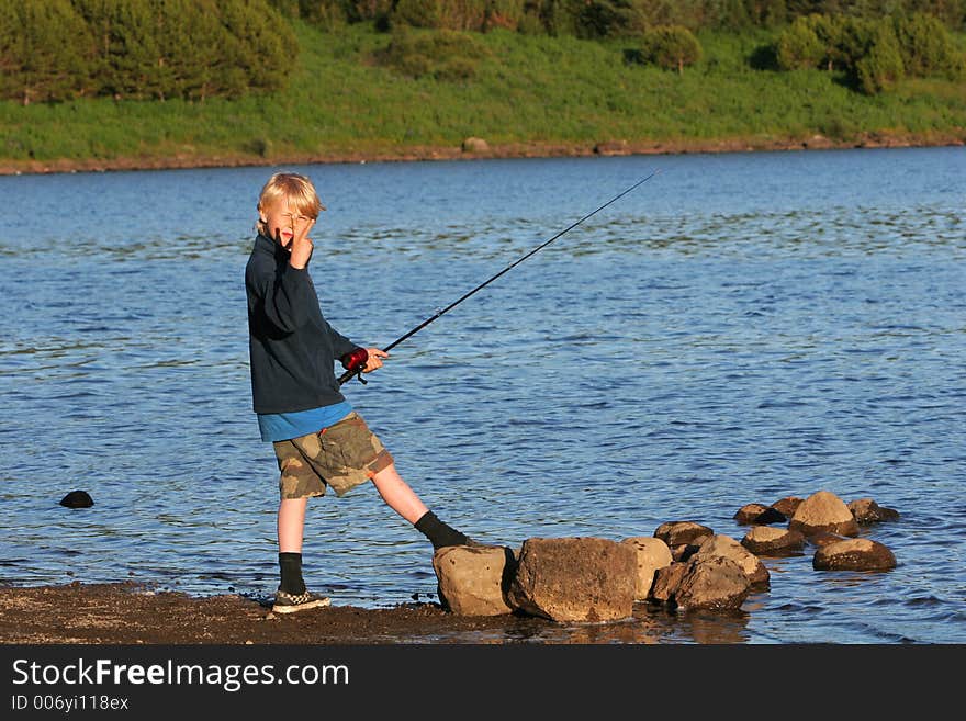 A boy fishing in a trout lake in northern europe. A boy fishing in a trout lake in northern europe