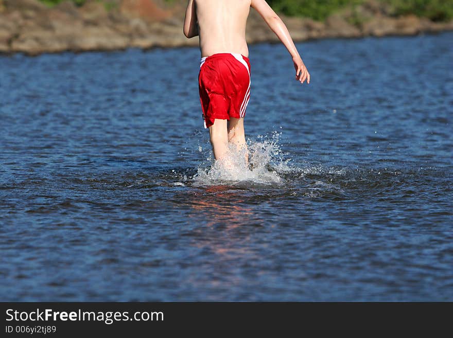 A young boy cooling of in lake on a hot summerday. A young boy cooling of in lake on a hot summerday