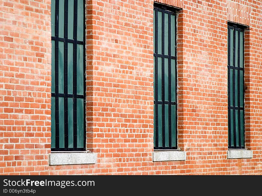 Three windows in old restored red brick building.