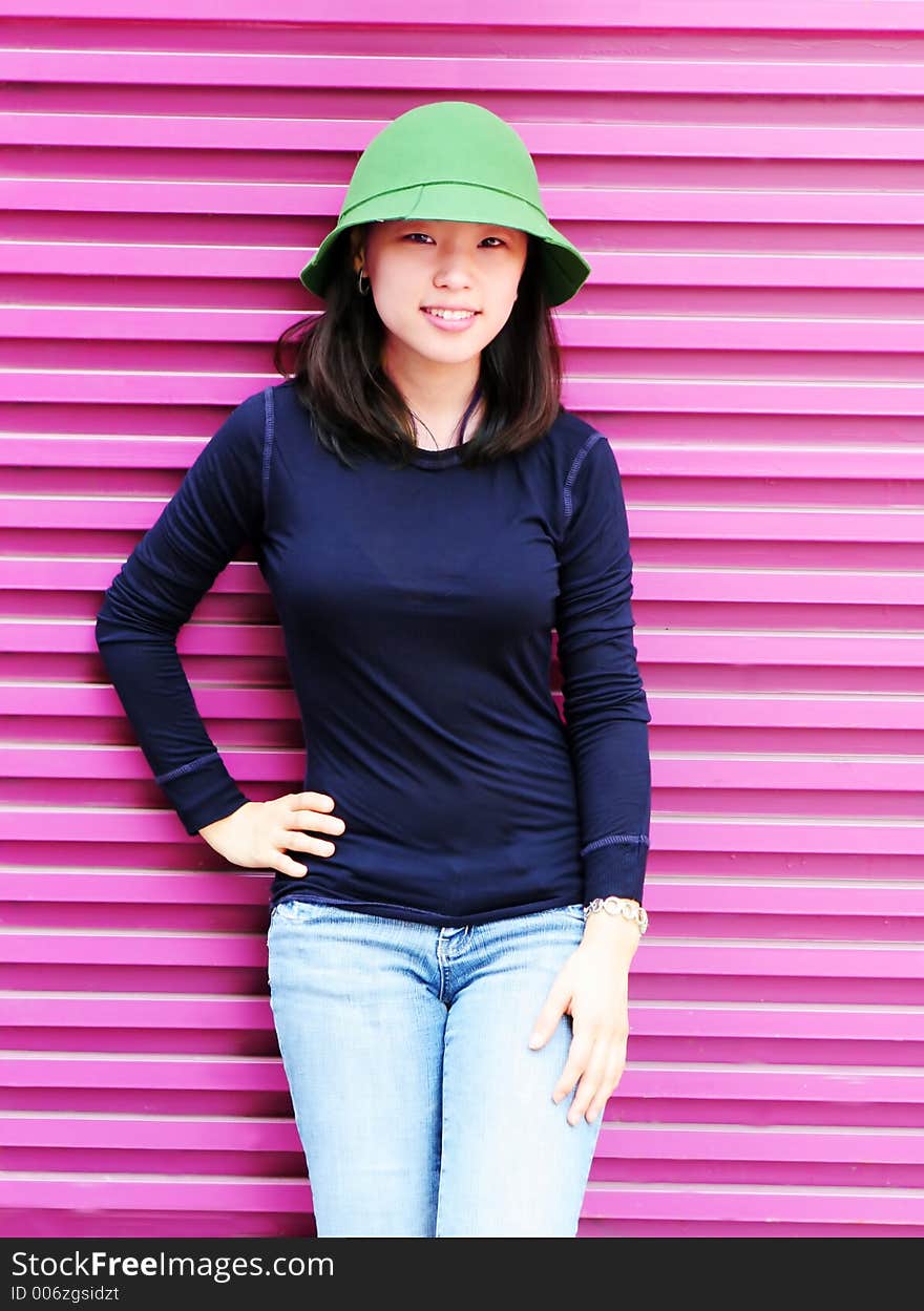 Pretty Korean woman in front of a pink wall. Pretty Korean woman in front of a pink wall