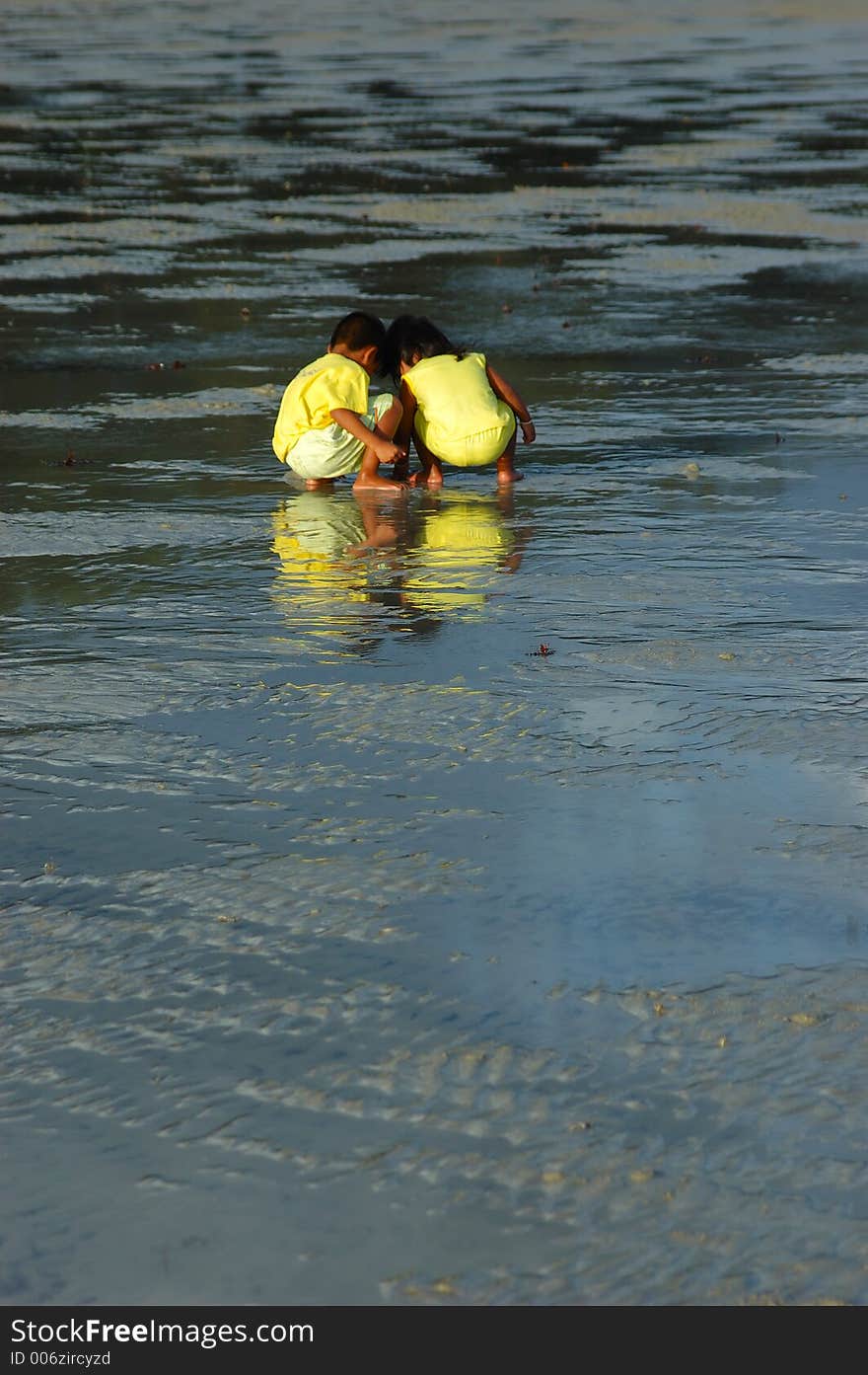 A small boy and small girl play in sand. A small boy and small girl play in sand.