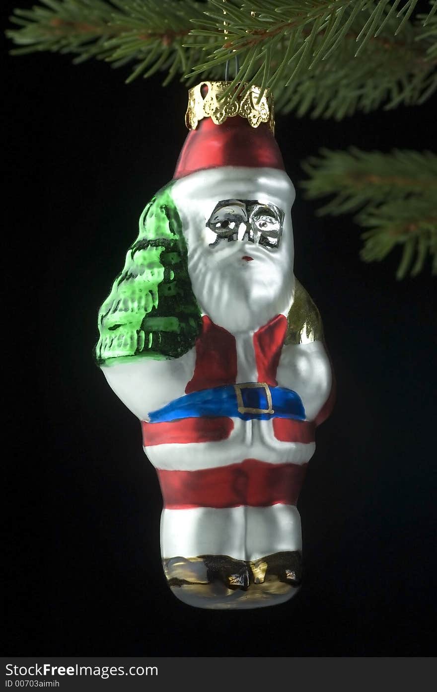 Glass Santa Christmas ornament hanging on a Christmas tree branch.