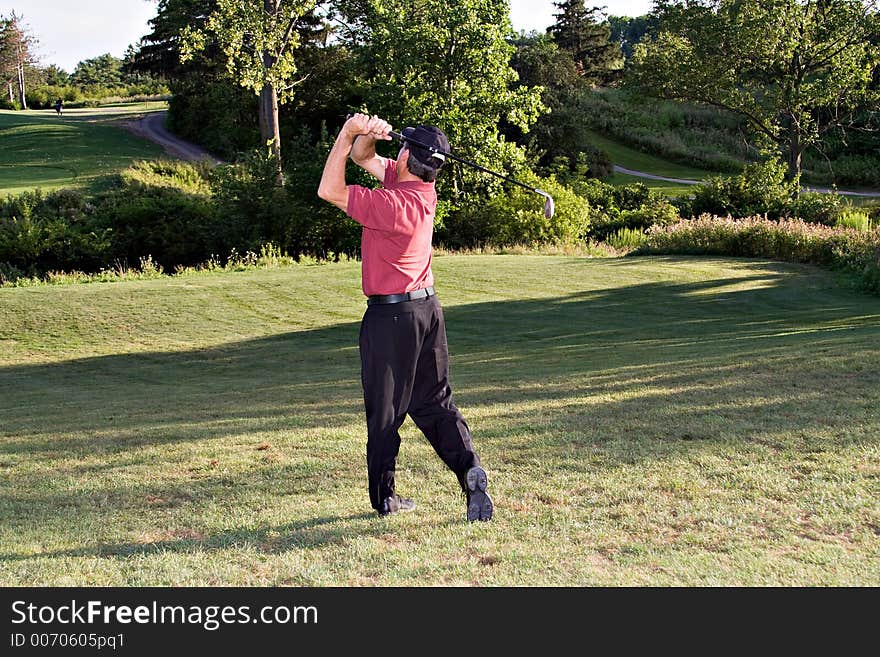 Golfer driving for the distant green. Golfer driving for the distant green.