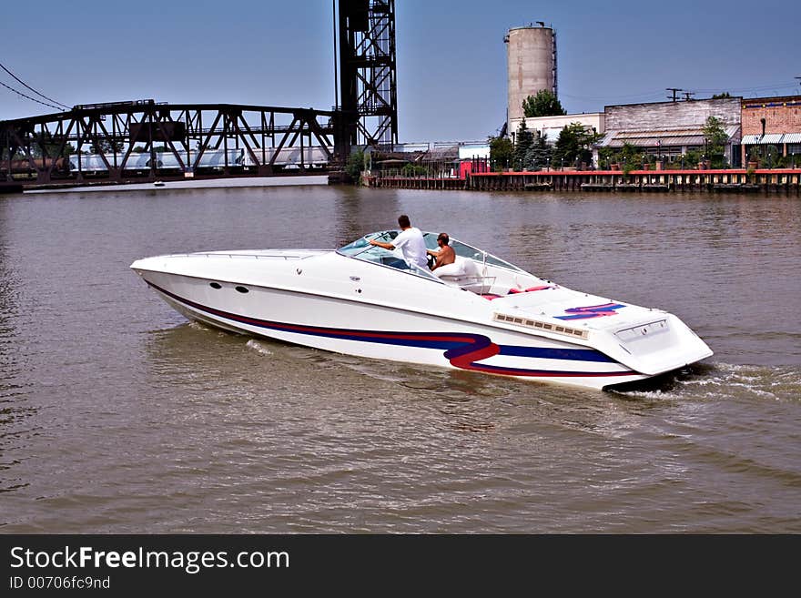 Two men crusing in a speedboat along the river that empties into Lake Erie. Railroad trestle bridge - train crossing. Bridge will raise after train has passes. Two men crusing in a speedboat along the river that empties into Lake Erie. Railroad trestle bridge - train crossing. Bridge will raise after train has passes.