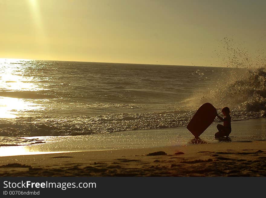 A siluet of a girl woth buggy Board on the beach. A siluet of a girl woth buggy Board on the beach