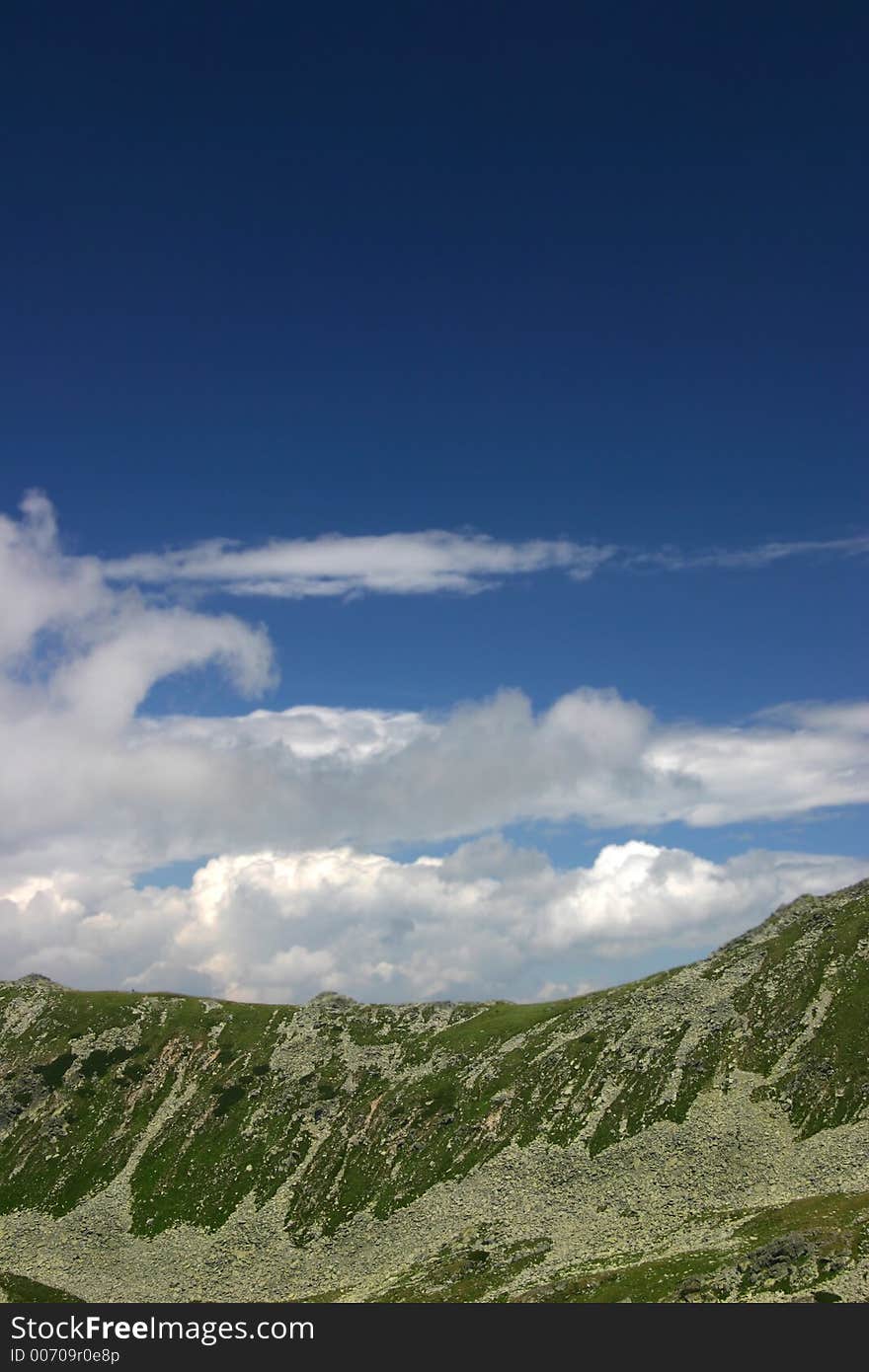 Peaks and beautiful dark blue sky with clouds on Retezat Mountains - Romania. Peaks and beautiful dark blue sky with clouds on Retezat Mountains - Romania