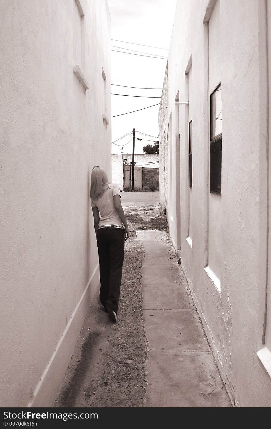 Monochrome photo of punk girl in an alley looking out the back way. Monochrome photo of punk girl in an alley looking out the back way.